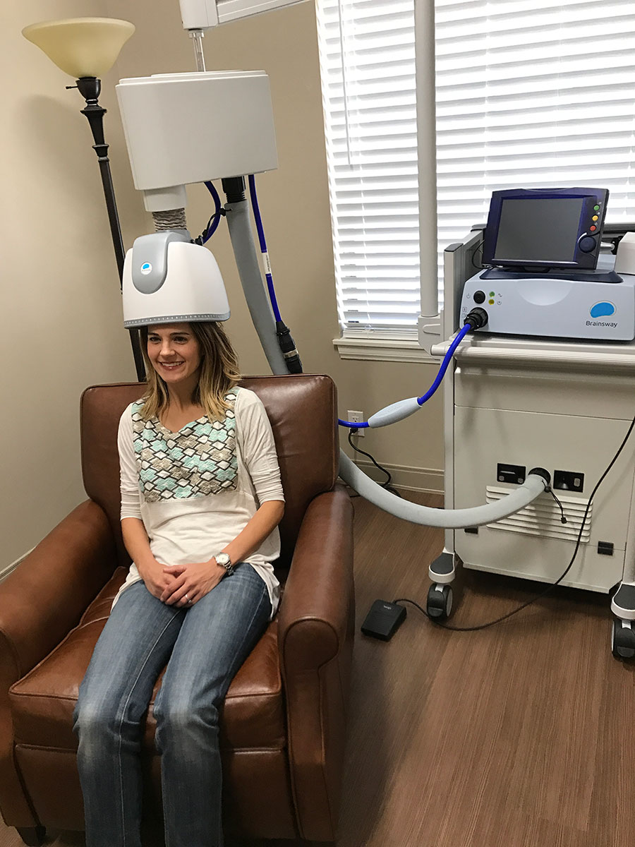 A woman sitting in a chair next to a machine.