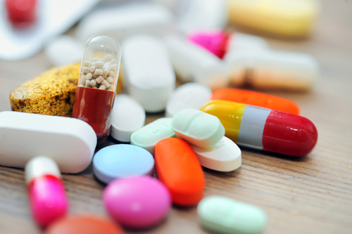 A group of pills and capsules on a table.