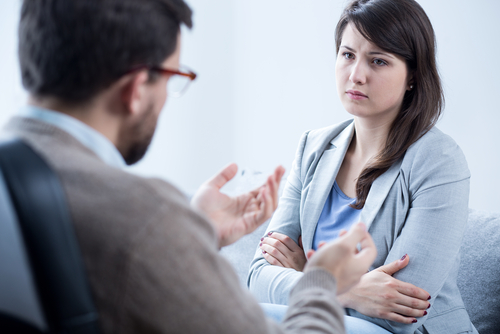 A woman talking to a man in an office.